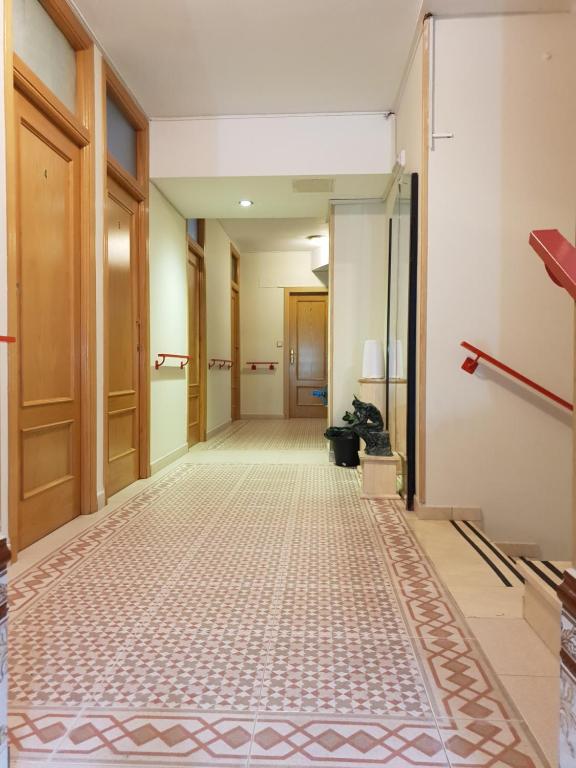 an empty hallway with a tile floor in a building at Residencial Oscense in Huesca