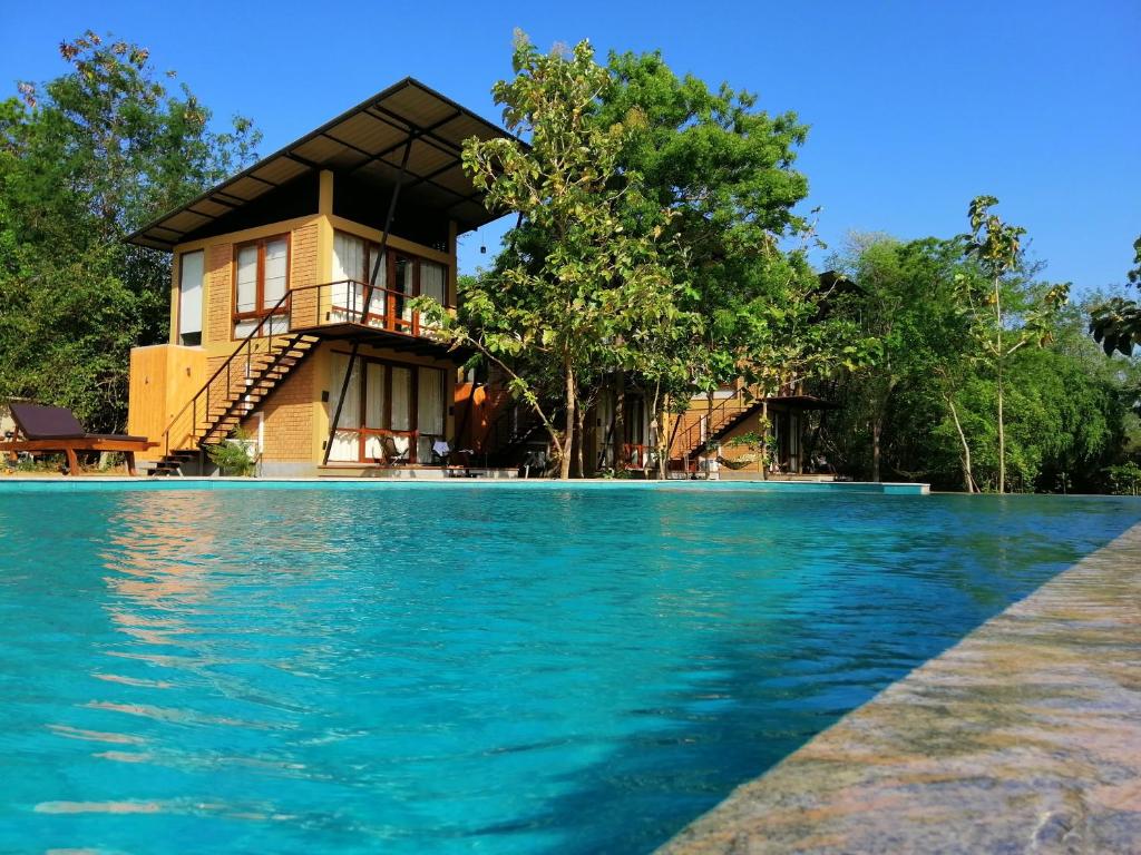 una casa con piscina frente a ella en Breezy Lake, en Tissamaharama