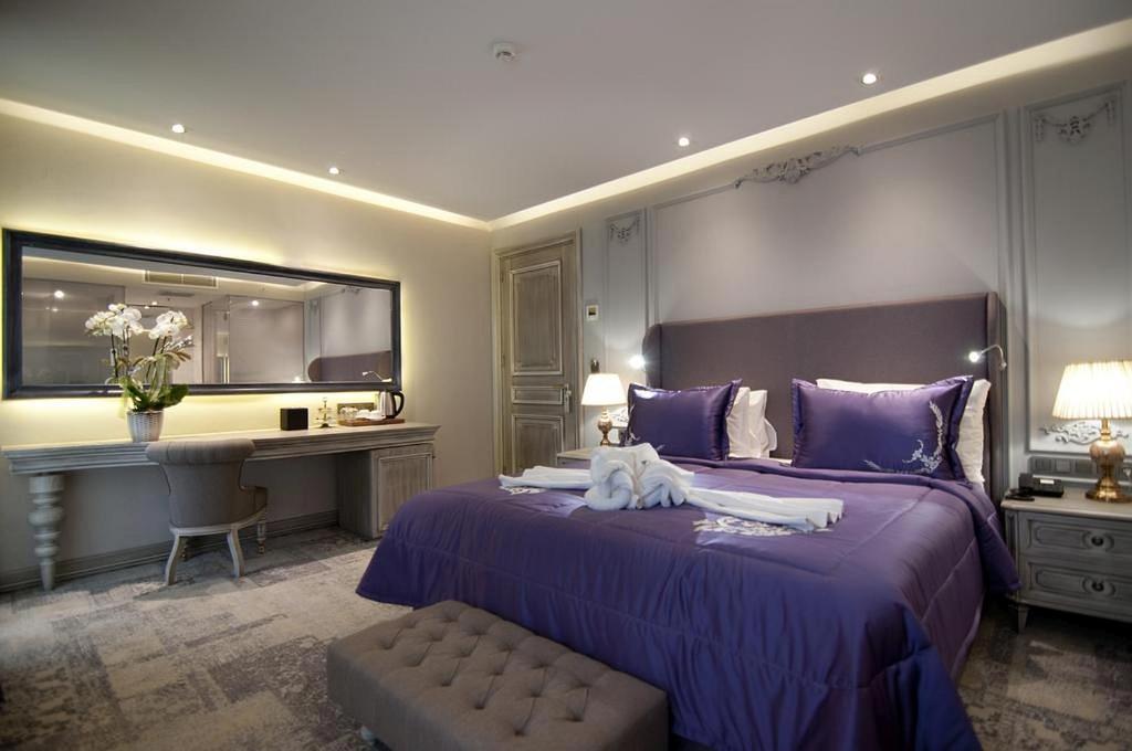 a bedroom with a large purple bed and a desk at TK Taxim Bosphorus Hotel in Istanbul