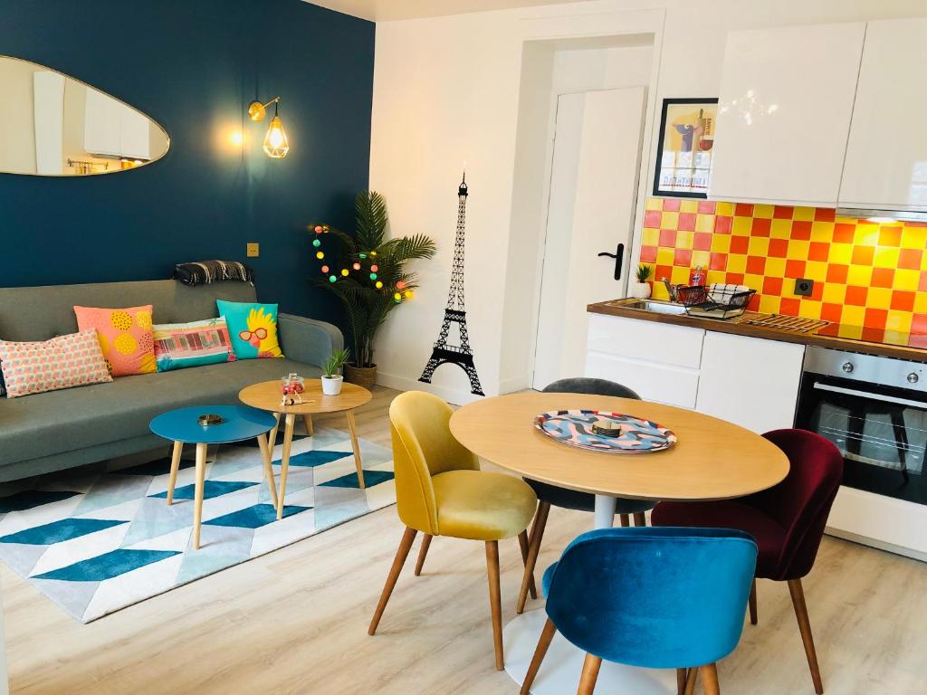 uma sala de estar com mesa e cadeiras e uma cozinha em Relais Cocorico Fondary Apartment Eiffel Tower District em Paris