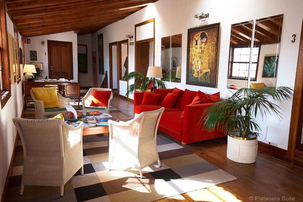 a living room with a red couch and chairs at Platanera Suites in Icod de los Vinos