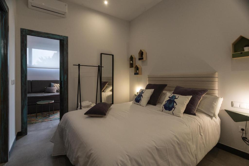 1 dormitorio con 1 cama grande y ventana grande en TRIA NOMINA Apartamentos Turísticos, en Mérida
