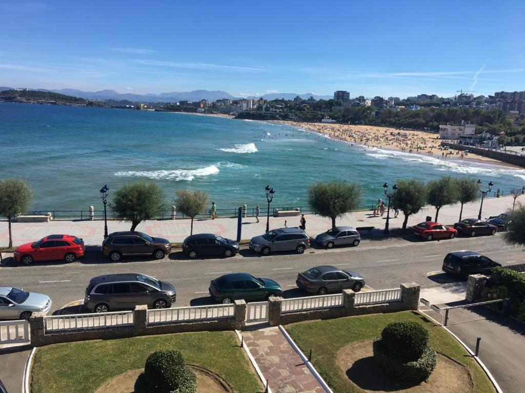 a parking lot with cars parked next to the beach at VISTAS AL MAR in Santander