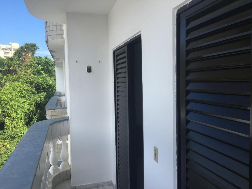eine schwarze Tür an der Seite eines weißen Gebäudes in der Unterkunft Acomodação no paraíso in Ubatuba