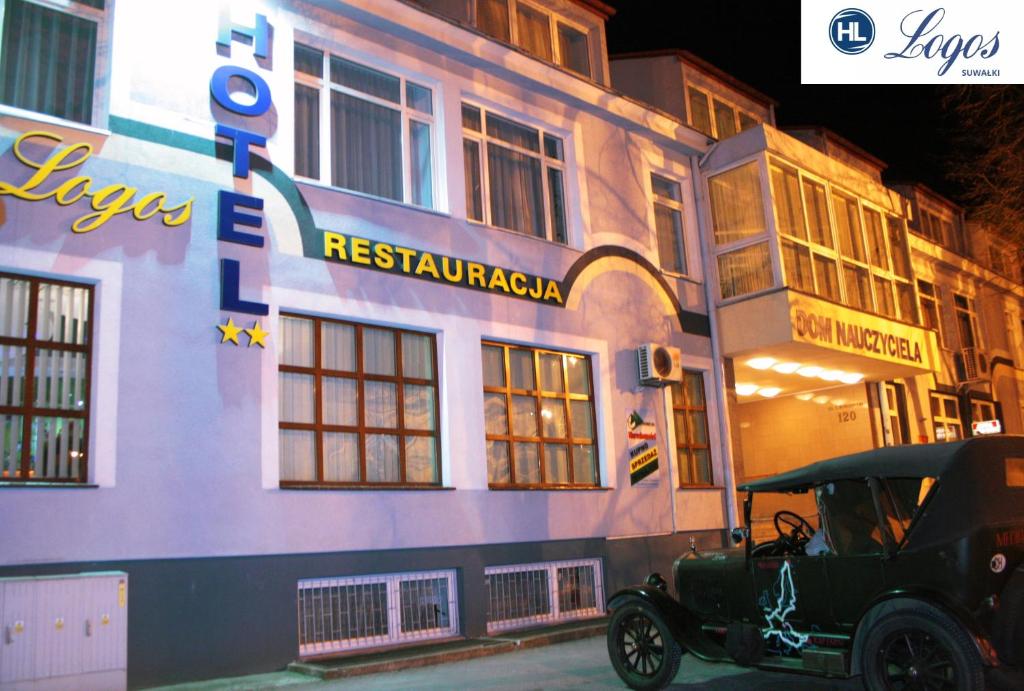 an old car parked in front of a building at Hotel Logos in Suwałki