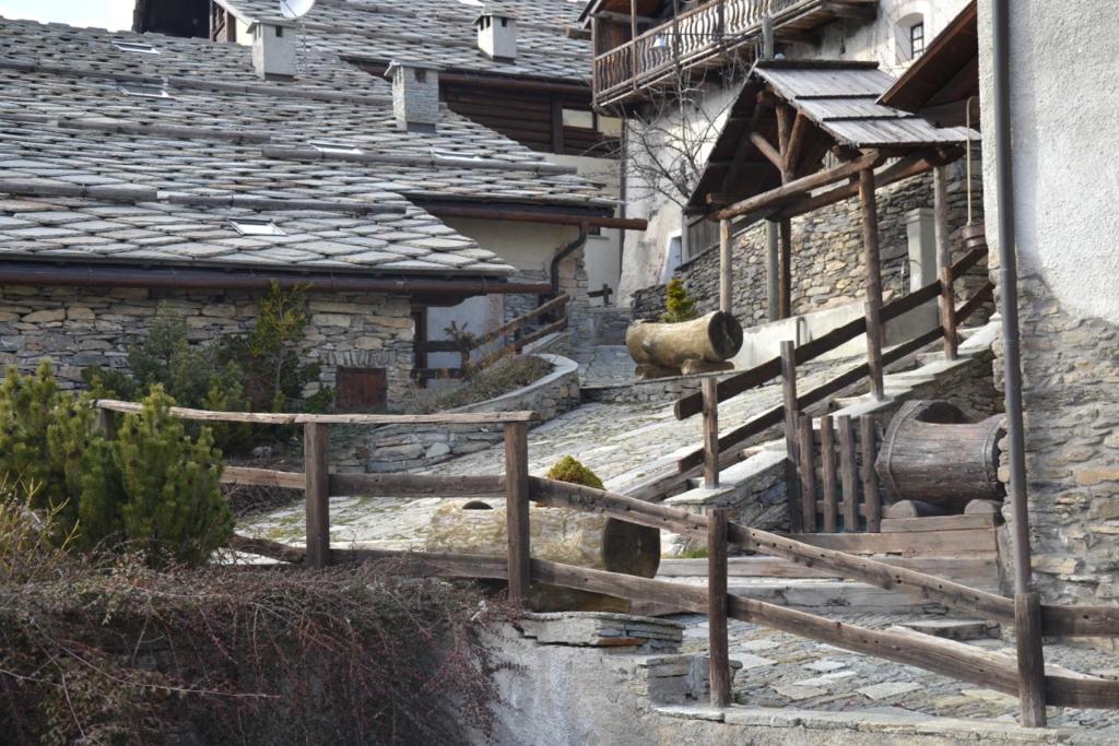 una pecora che giace sui gradini di un edificio di Grangia in borgo antico a Bardonecchia