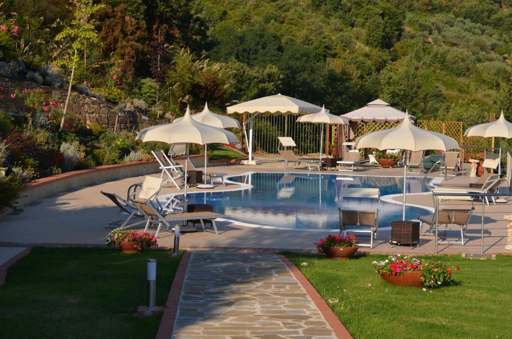 basen z białymi parasolami, krzesłami, stołami i krzesłami w obiekcie Casa Vacanza Villa Aurora w mieście Laureana Cilento