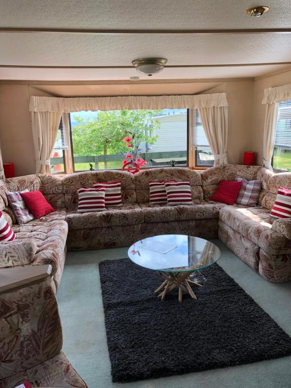 a living room with a couch and a glass table at 23 Glenfinart Caravan Park in Dunoon