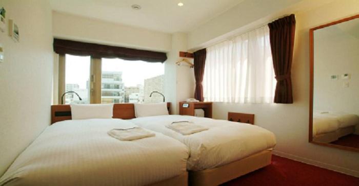 Postel nebo postele na pokoji v ubytování Benikea Calton Hotel Osaka Doutonbori
