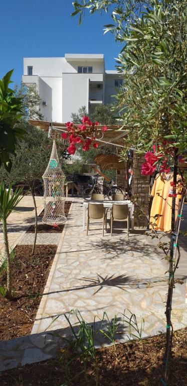 een patio met een tafel en stoelen en een gebouw bij Guest House Solive in Himare