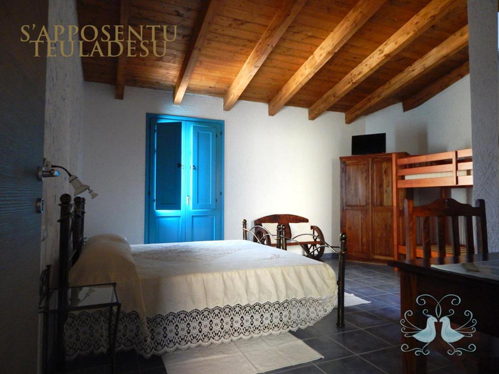 a bedroom with a bed and a blue door at S'Apposentu Teuladesu Affittacamere del Ristorante da Stefano in Teulada