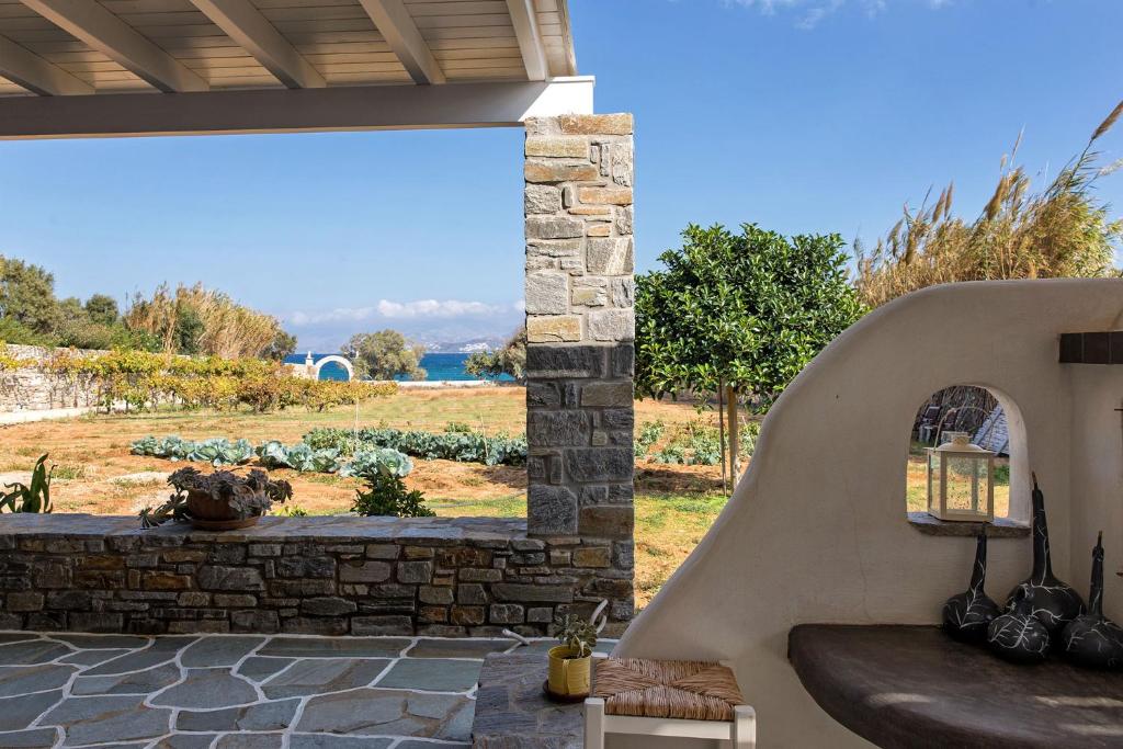 a patio with a stone wall and a bench at BilMar little palace/ steps from the beach in Mármara