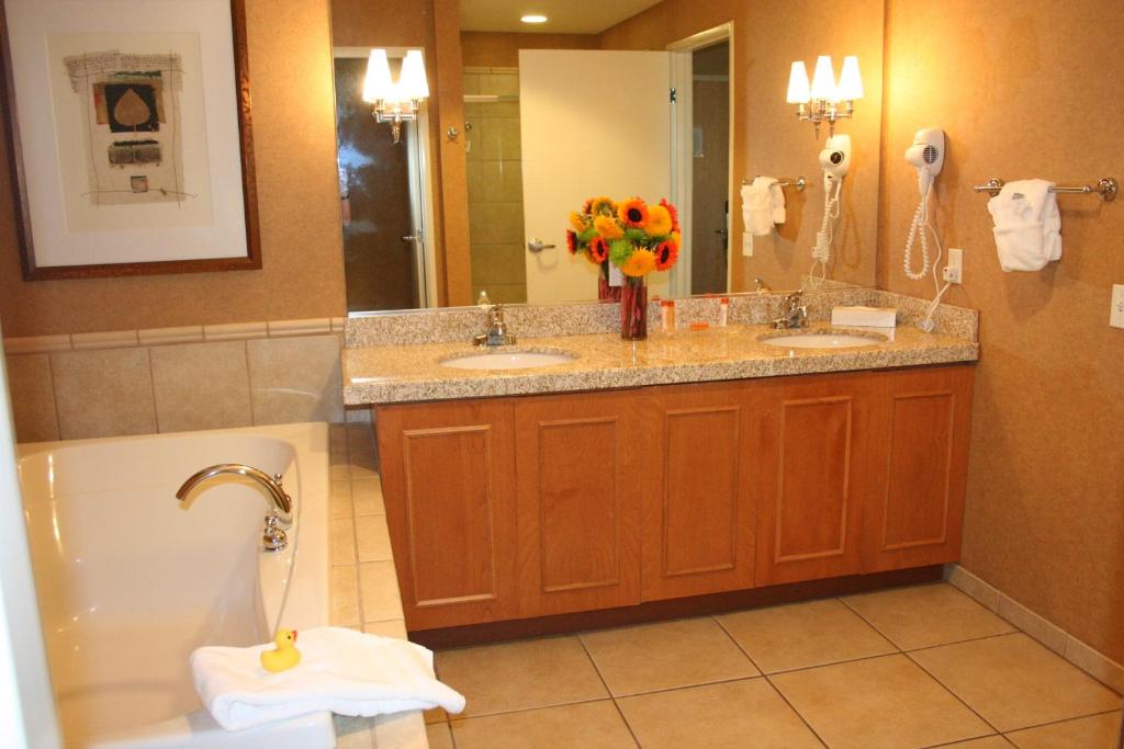 a bathroom with two sinks and a tub and a toilet at Gold Country Casino Resort in Oroville