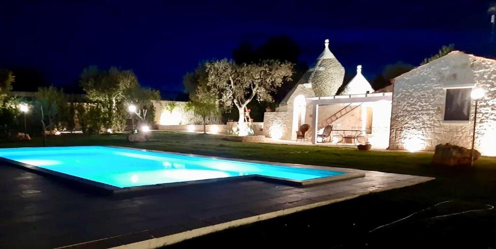una piscina davanti a una casa di notte di Trullo Rinaldi - Private Pool and Sauna a Castellana Grotte