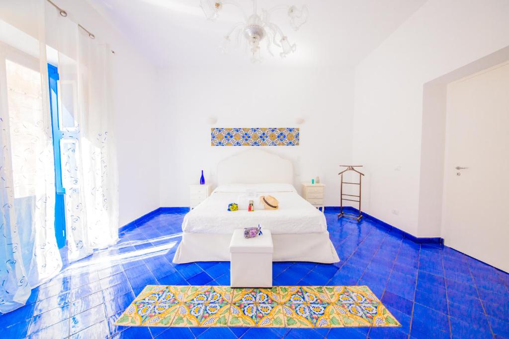 a bedroom with a bed and a blue tiled floor at Punta Sallustro Lipari in Lipari