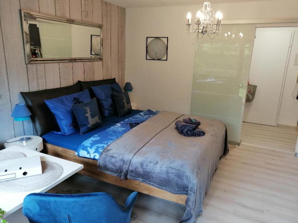 una camera da letto con un letto con lenzuola blu e uno specchio di Mike's Apartment inkl. Oberstaufen Plus Card a Oberstaufen
