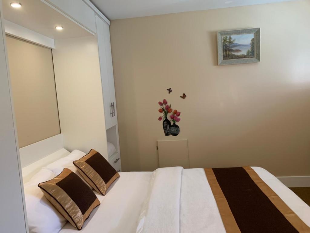 een slaapkamer met 2 bedden en een vaas met bloemen aan de muur bij Mekong Star in Vancouver
