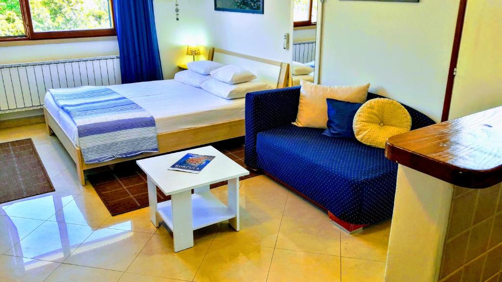 una camera con letto, divano e tavolo di Apartments Iris a Korčula
