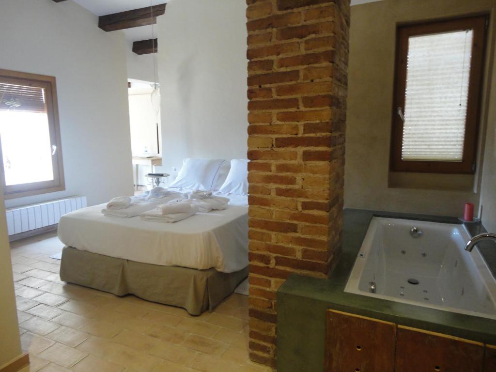 a bedroom with a bed and a bath tub at Hotel Rural Cal Torner Adults Only in Guiamets