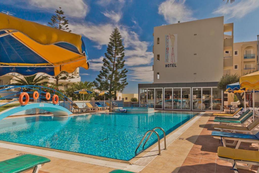 Olympic Hotel في كارباثوس: مسبح في منتجع فيه كراسي ومظلات