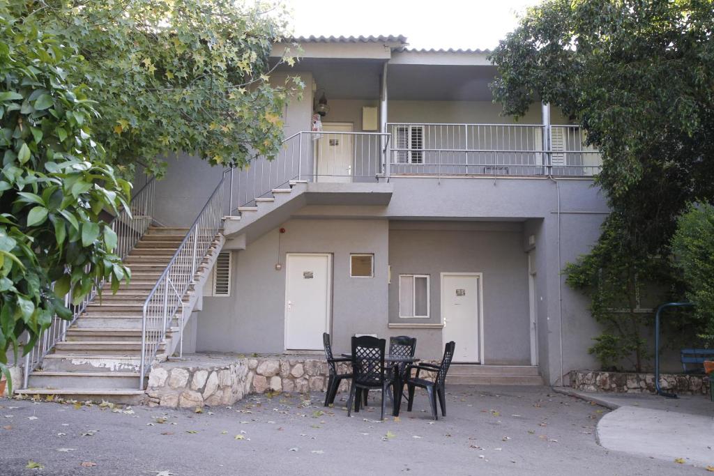 dos sillas y una mesa frente a un edificio en Kibbutz Beit Alfa Guest House, en Bet Alfa