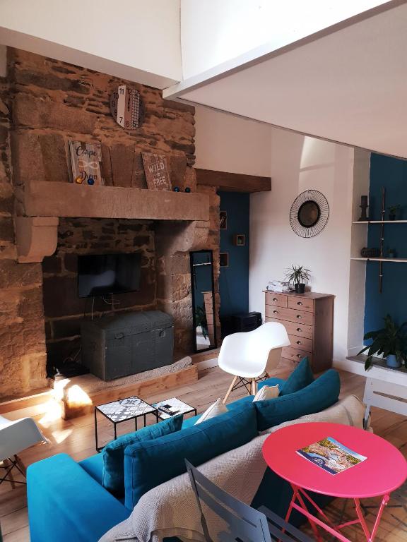 - un salon avec des canapés bleus et une cheminée dans l'établissement Studio Du Marche, à Dinan