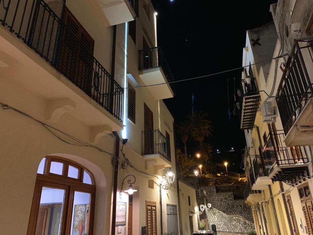 um beco com escadas e edifícios à noite em Badia Rooms & Breakfast em Castellammare del Golfo