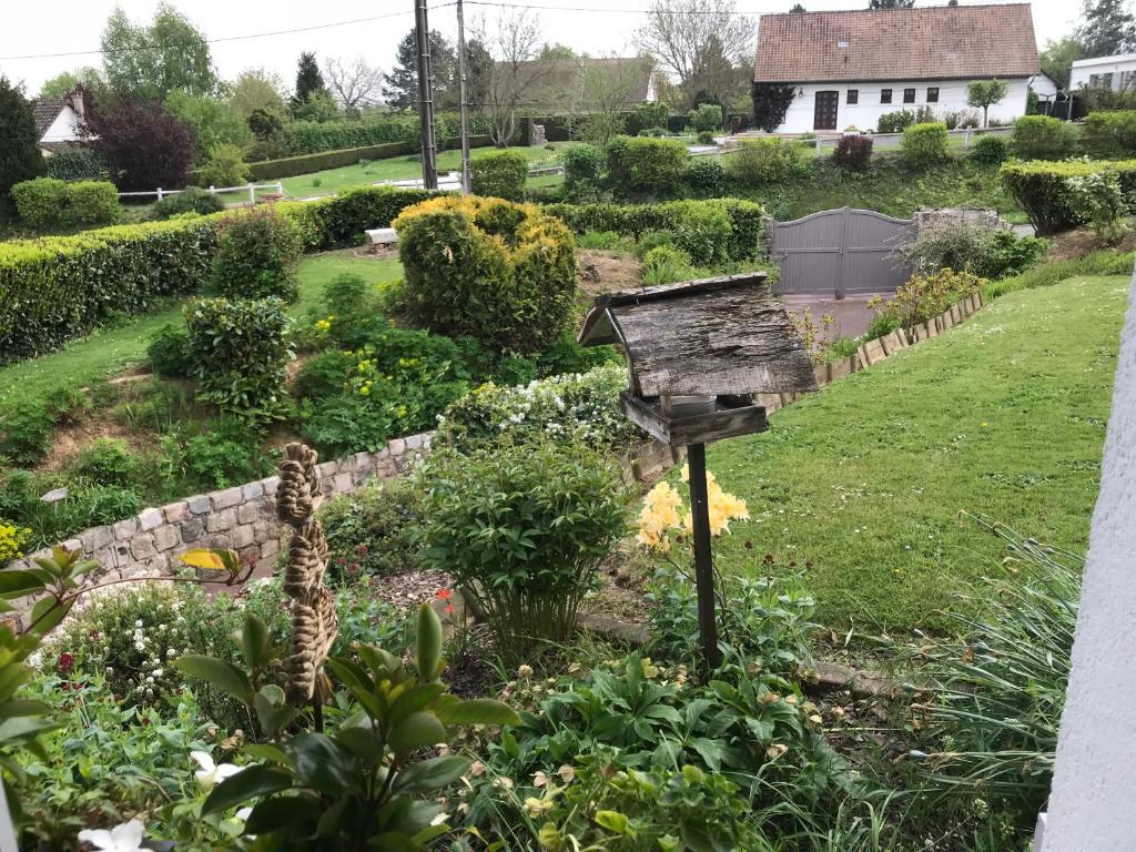 een tuin met een vogelhuisje in het midden bij le jardin adele in Drucat