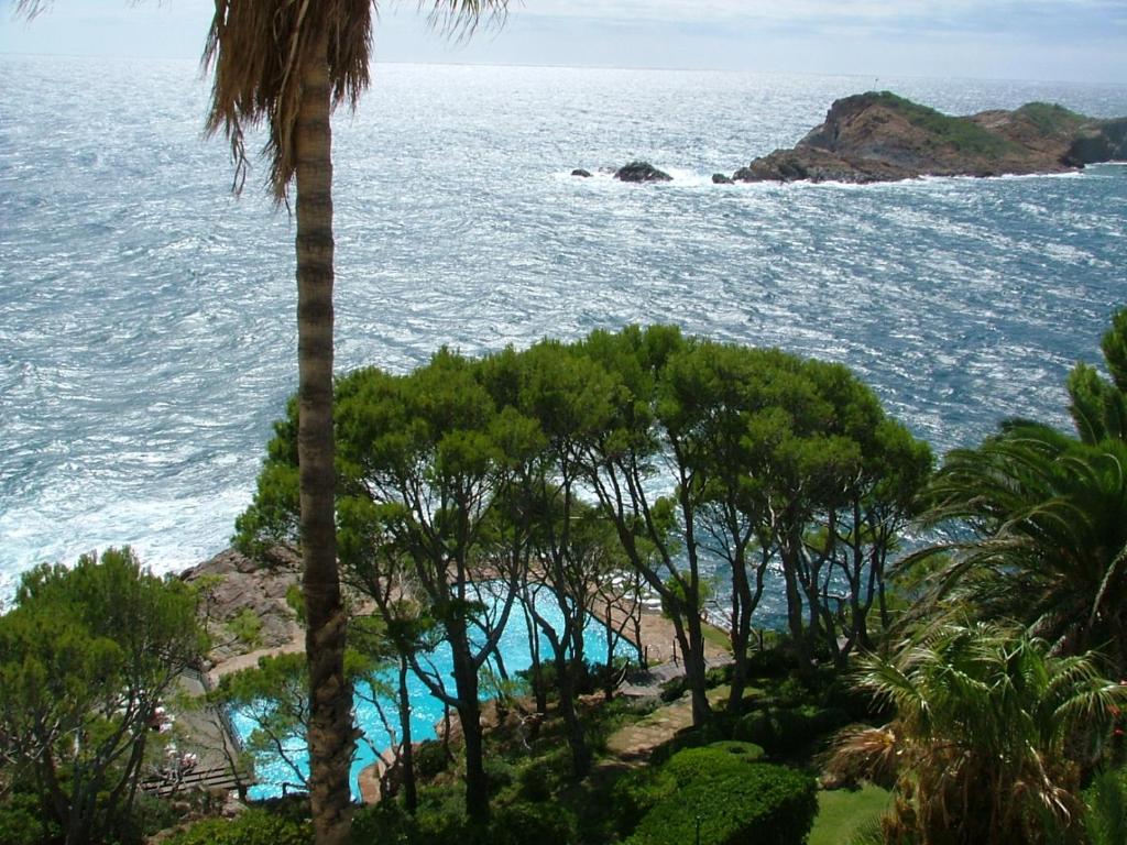 uma vista para o oceano a partir de um resort com palmeiras em Cap Sa Sal Navy, Begur, Girona em Begur