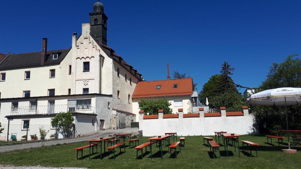 eine Gruppe von Tischen und Stühlen vor einem Gebäude in der Unterkunft Schloss Weichs zu Regensburg mit 1-2Schlafzimmer Parkplatz Internet 60qm Zentrum in Regensburg