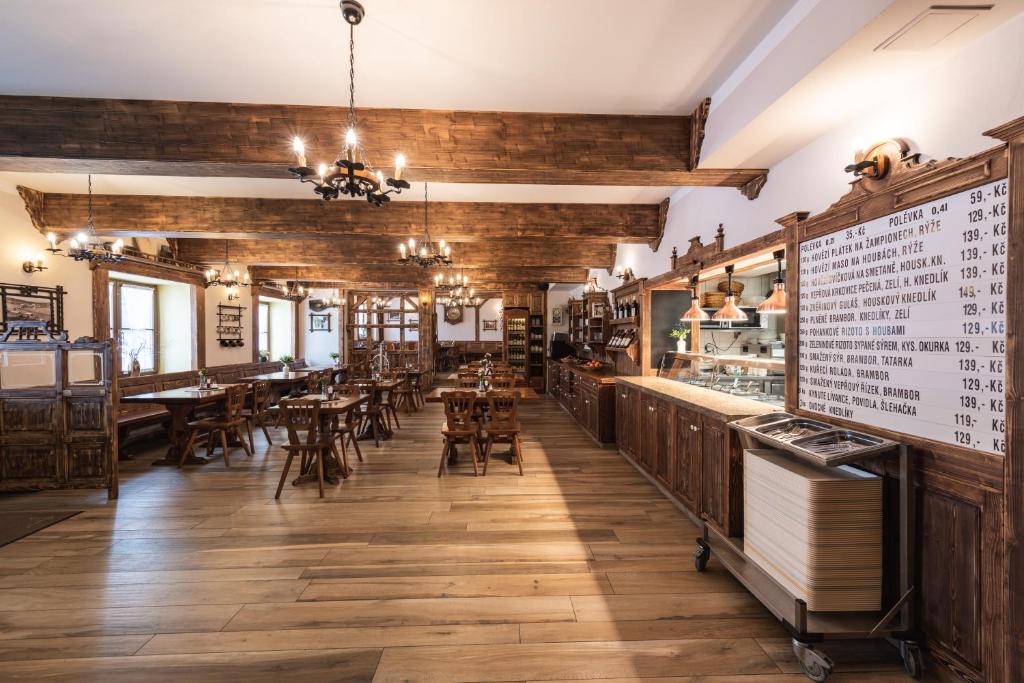 restauracja z drewnianymi ścianami, stołami i krzesłami w obiekcie Hotel Rankl w mieście Horská Kvilda