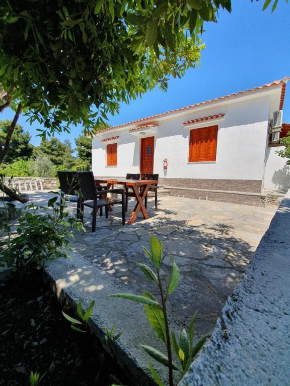 a house with a table and chairs in front of it at Panos Villas in Koukounaries