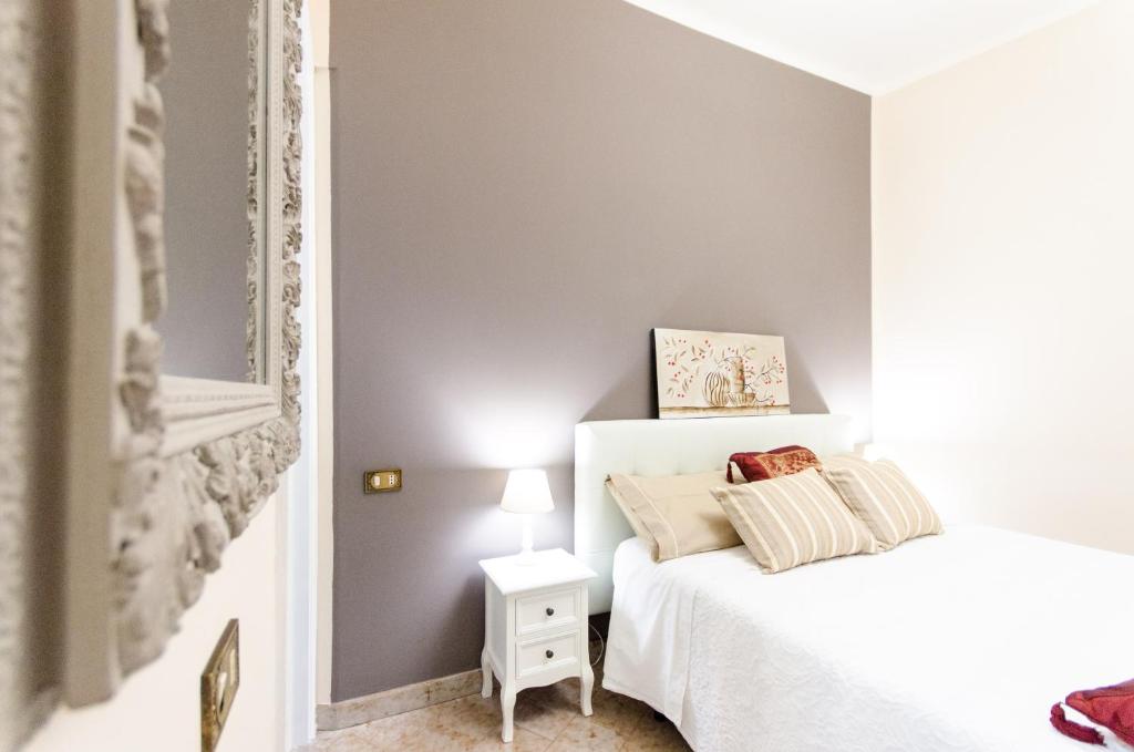 a bedroom with a white bed and a mirror at Saint Philippe Maison in Aci Catena
