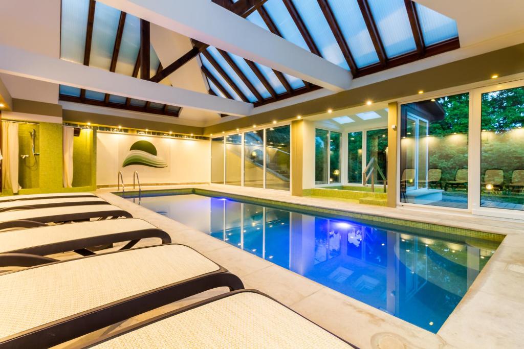 an indoor pool with lounge chairs in a house at Edenrock Stairs in Leányfalu