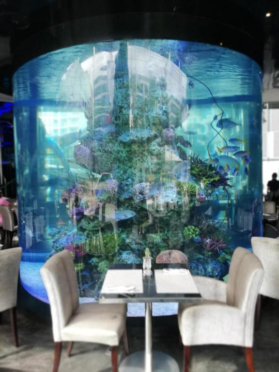 a table and chairs in front of a large aquarium at Centara Avenue apartment 711 in Pattaya