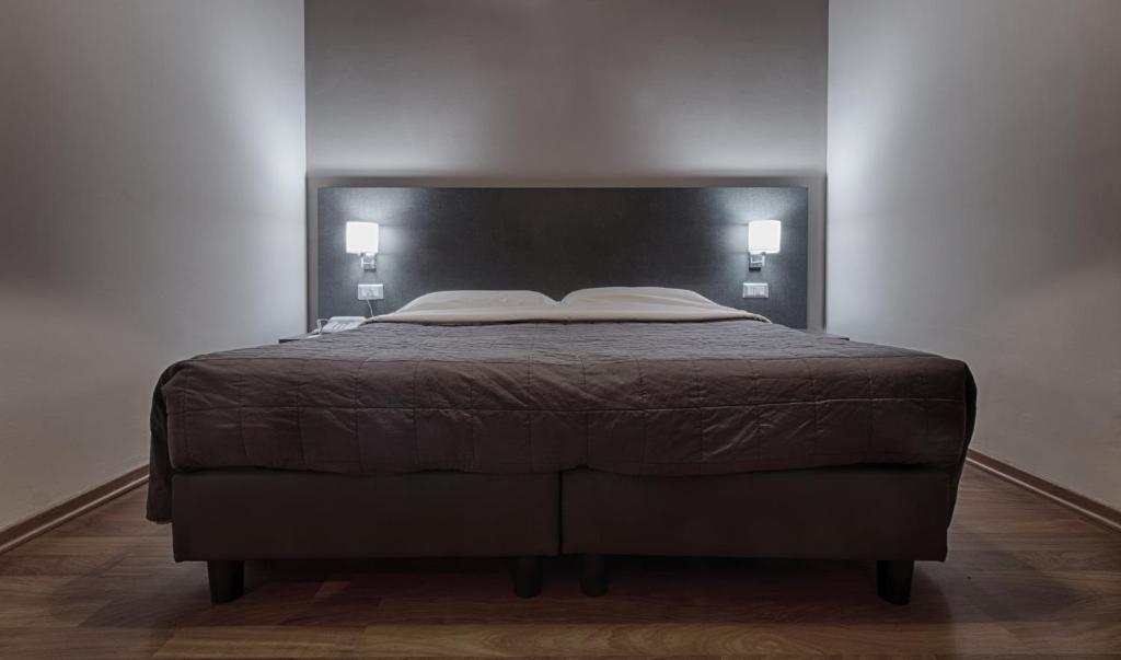 a bedroom with a bed with a black headboard at Twelve Hotel in Moncalieri