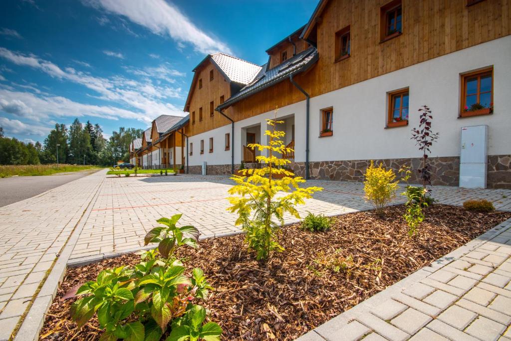 a building with a garden in front of it at Nova Lake Resort Nová Pec - Lipno in Nová Pec