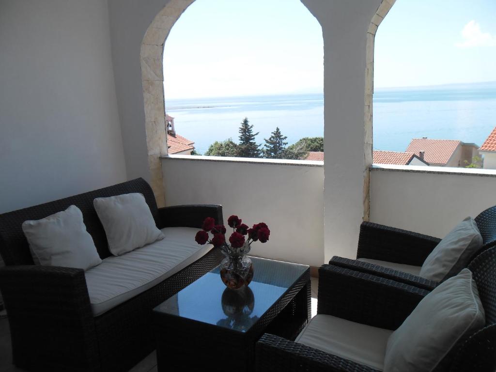 a living room with two couches and a table with flowers at Mirta in Stara Baška