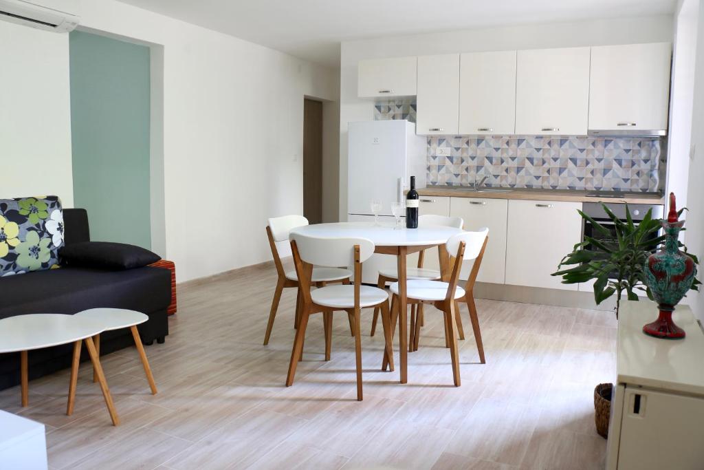 a kitchen and living room with a table and chairs at Velin Apartment in Split