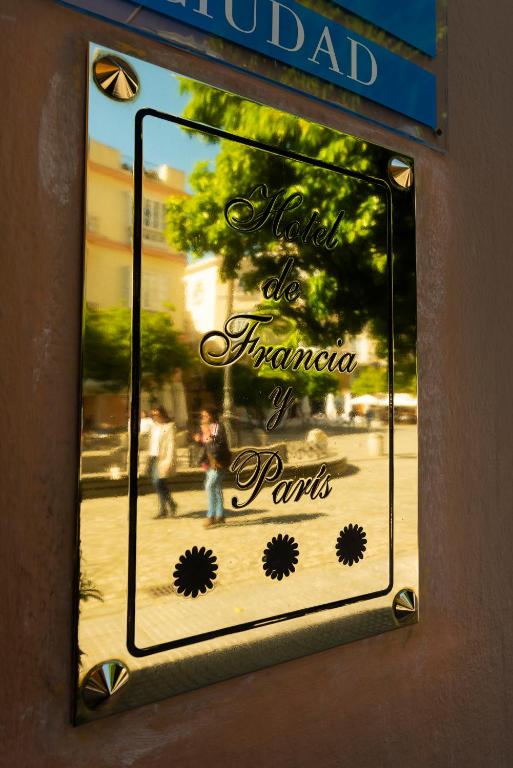 a sign for a parlor with people in the window at Hotel de Francia y París in Cádiz