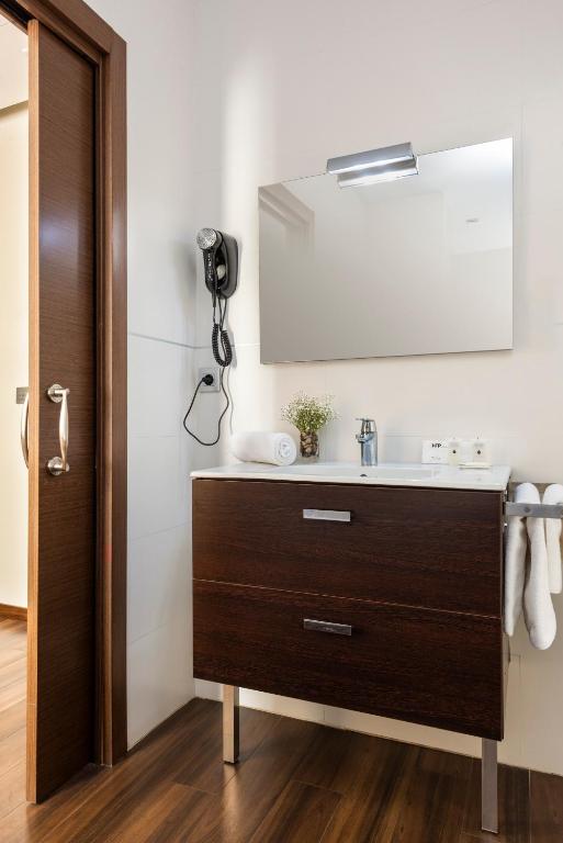a bathroom with a sink and a mirror at Hotel de Francia y París in Cádiz