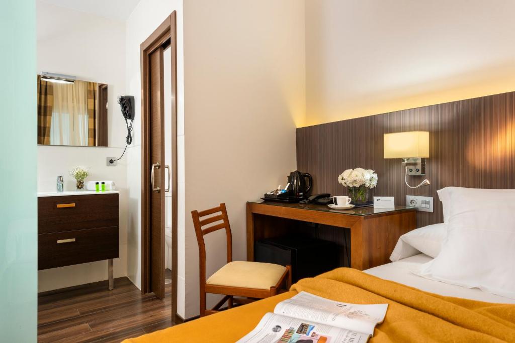a hotel room with a bed and a desk at Hotel de Francia y París in Cádiz