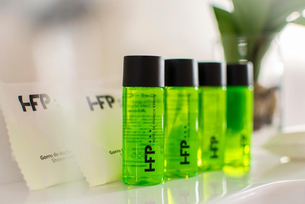 three green bottles of hair products sitting on a counter at Hotel de Francia y París in Cádiz