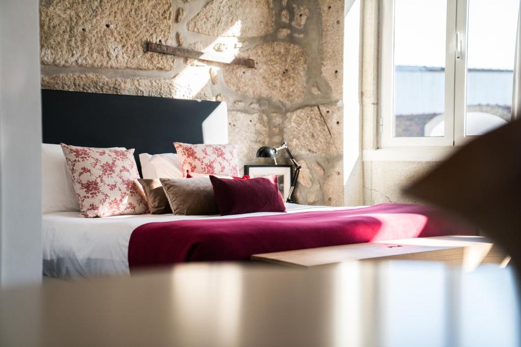 - une chambre avec un lit doté d'oreillers et d'une fenêtre dans l'établissement Downtown Residence by Apartments2Enjoy, à Porto