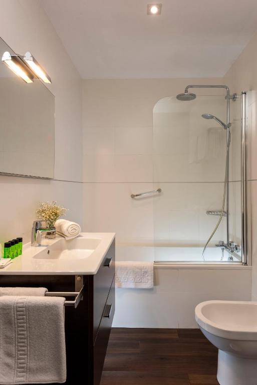 a bathroom with a sink and a shower and a toilet at Hotel de Francia y París in Cádiz
