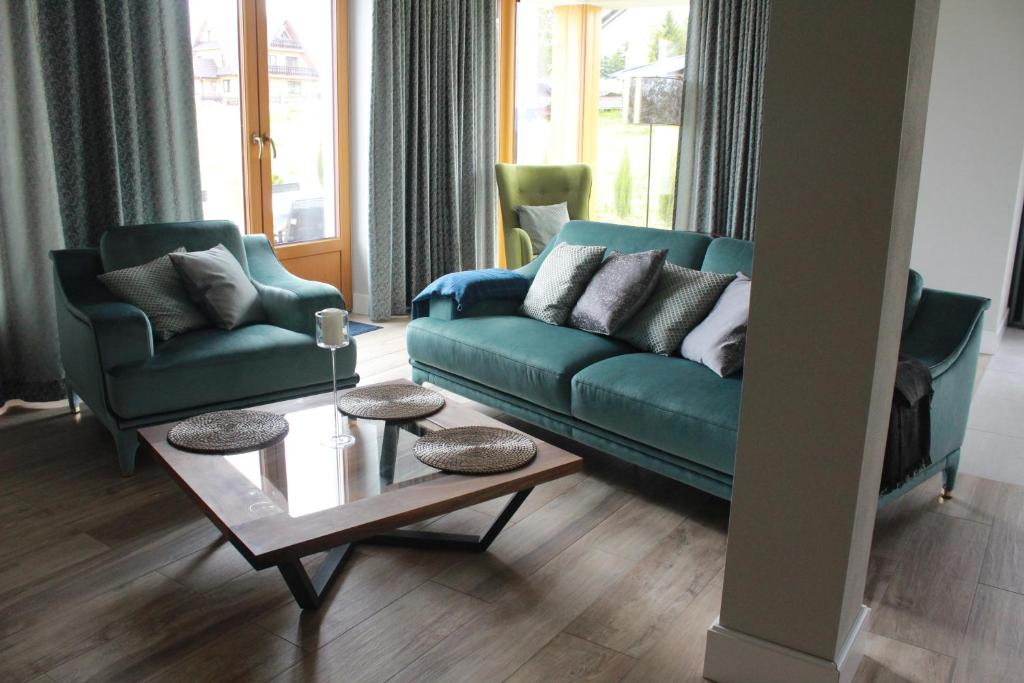 a living room with a green couch and two chairs at Monsieur Henri in Gronków