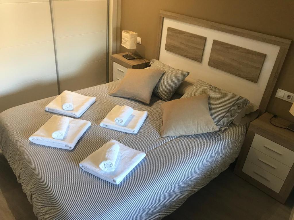デニアにあるApartamentos Loretoのベッド1台(タオル2枚、枕2つ付)
