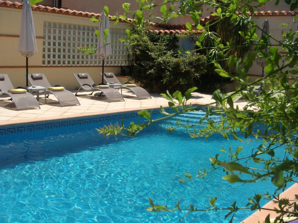 - un groupe de chaises et une piscine dans l'établissement Mas Grandiflora, à Espira-de-lʼAgly
