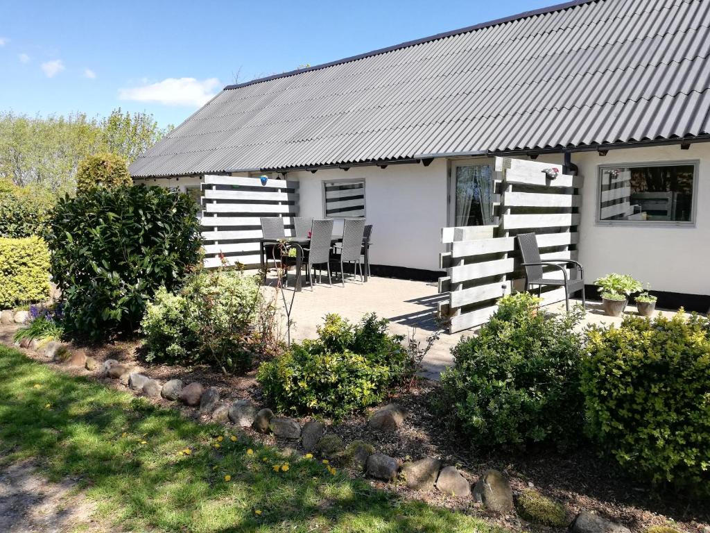 a house with a table and chairs in front of it at Bindesbølgård Farm Holiday in Give