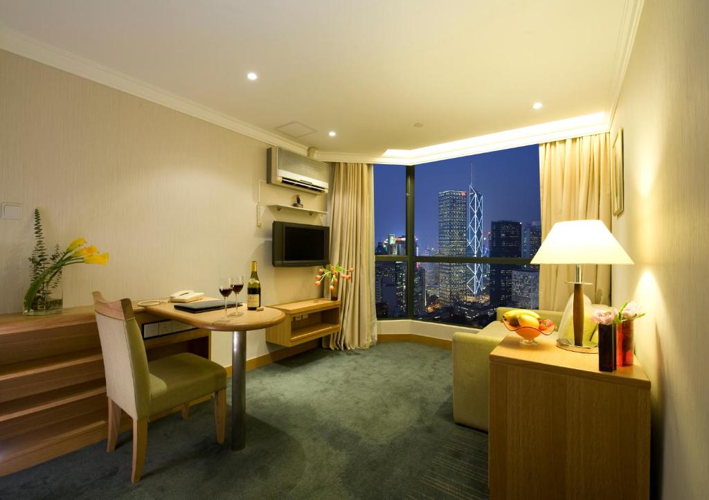a hotel room with a desk and a room with a window at Bishop Lei International House in Hong Kong